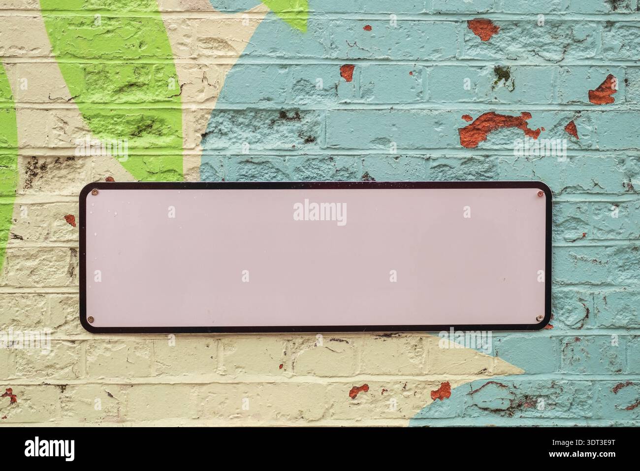 Panneau vierge avec espace pour le texte sur le mur de briques peintes colorées Banque D'Images