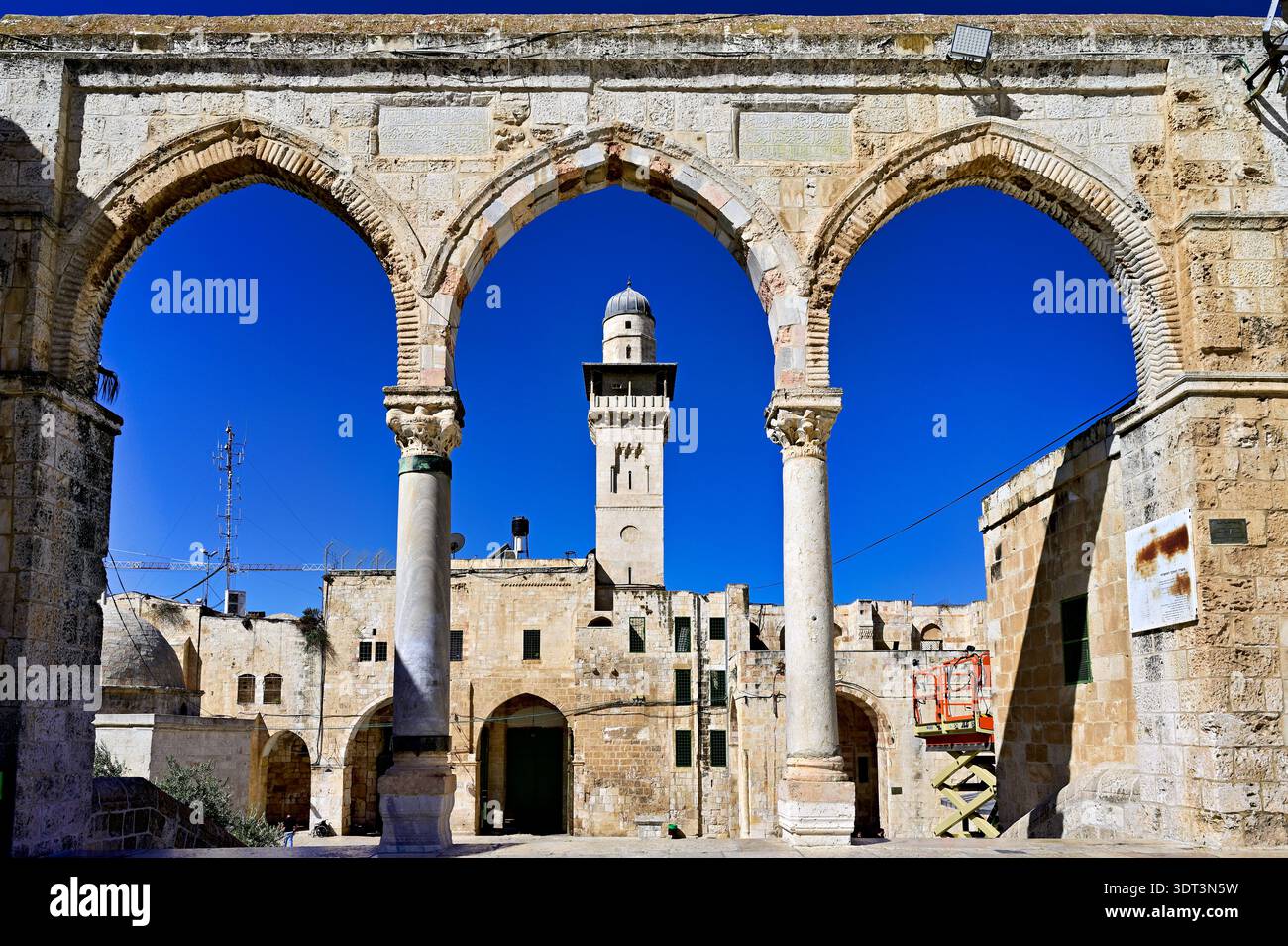Les visiteurs voient la mosquée Dôme du Rocher à travers des arches au Mont du Temple à Jérusalem par une journée ensoleillée. Banque D'Images