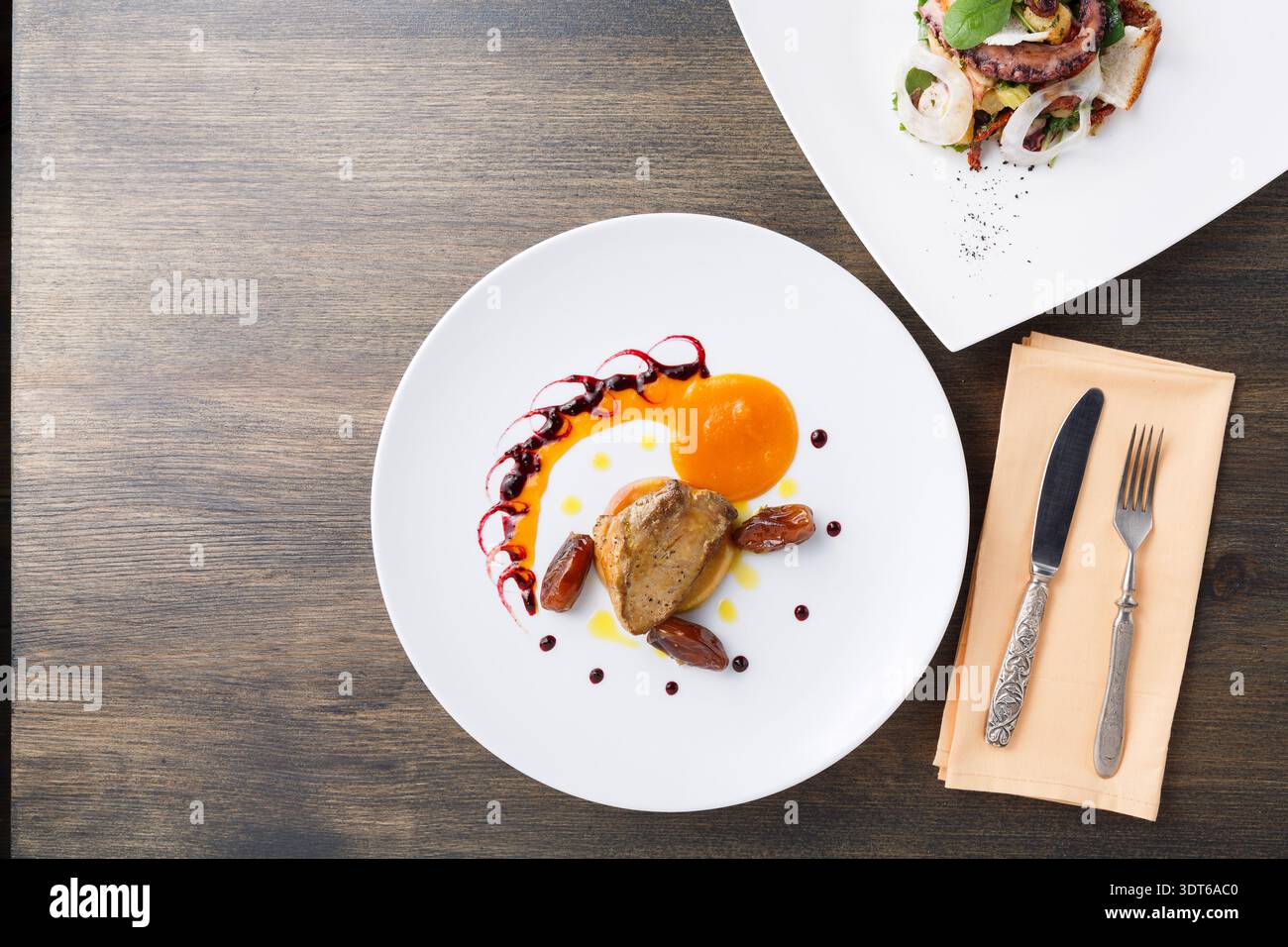 Expérience gastronomique avec deux plats plats sur une table en bois Banque D'Images