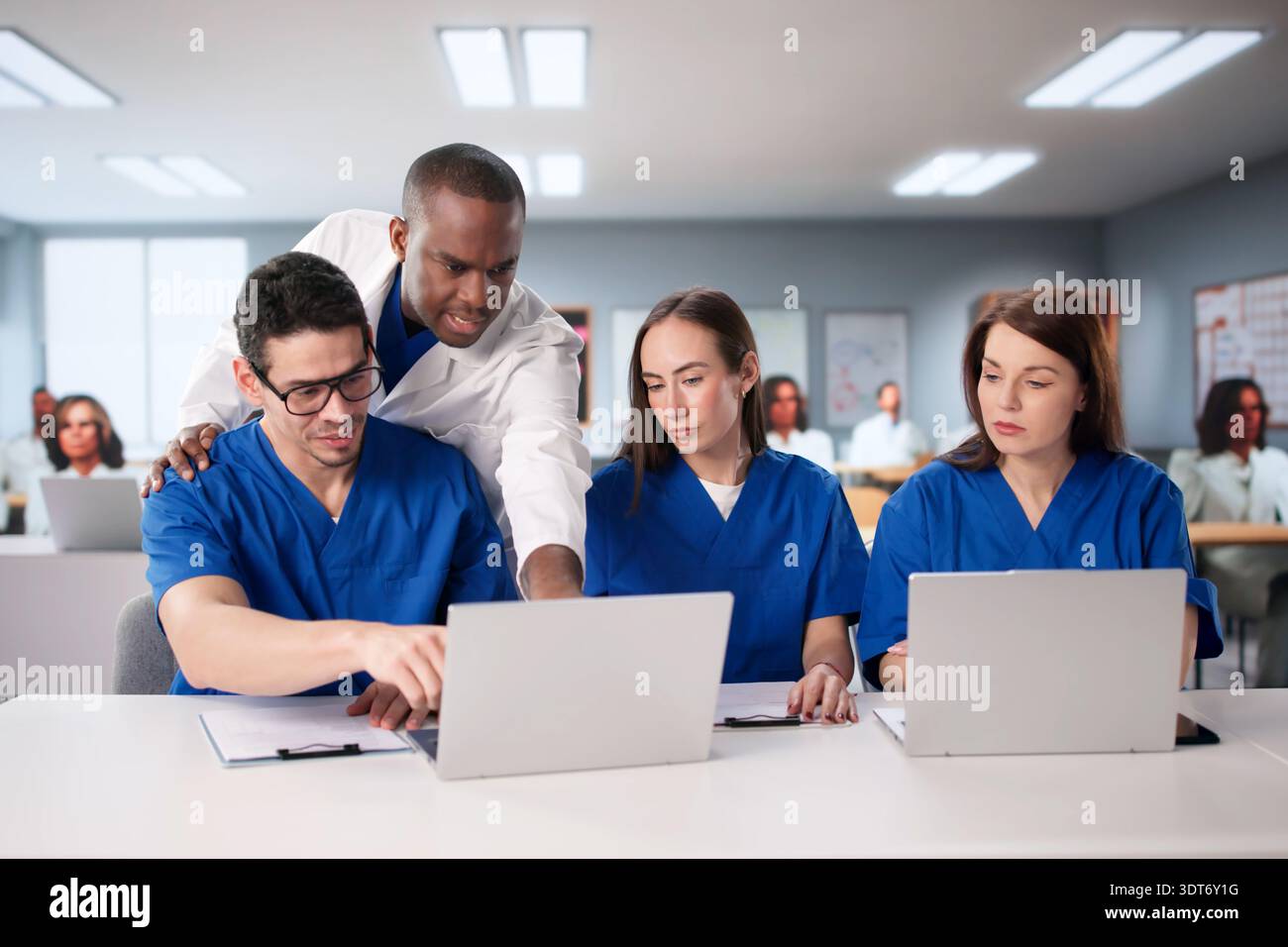 Étudiants en médecine étudiant avec un docteur sur un ordinateur portable de classe universitaire. Banque D'Images