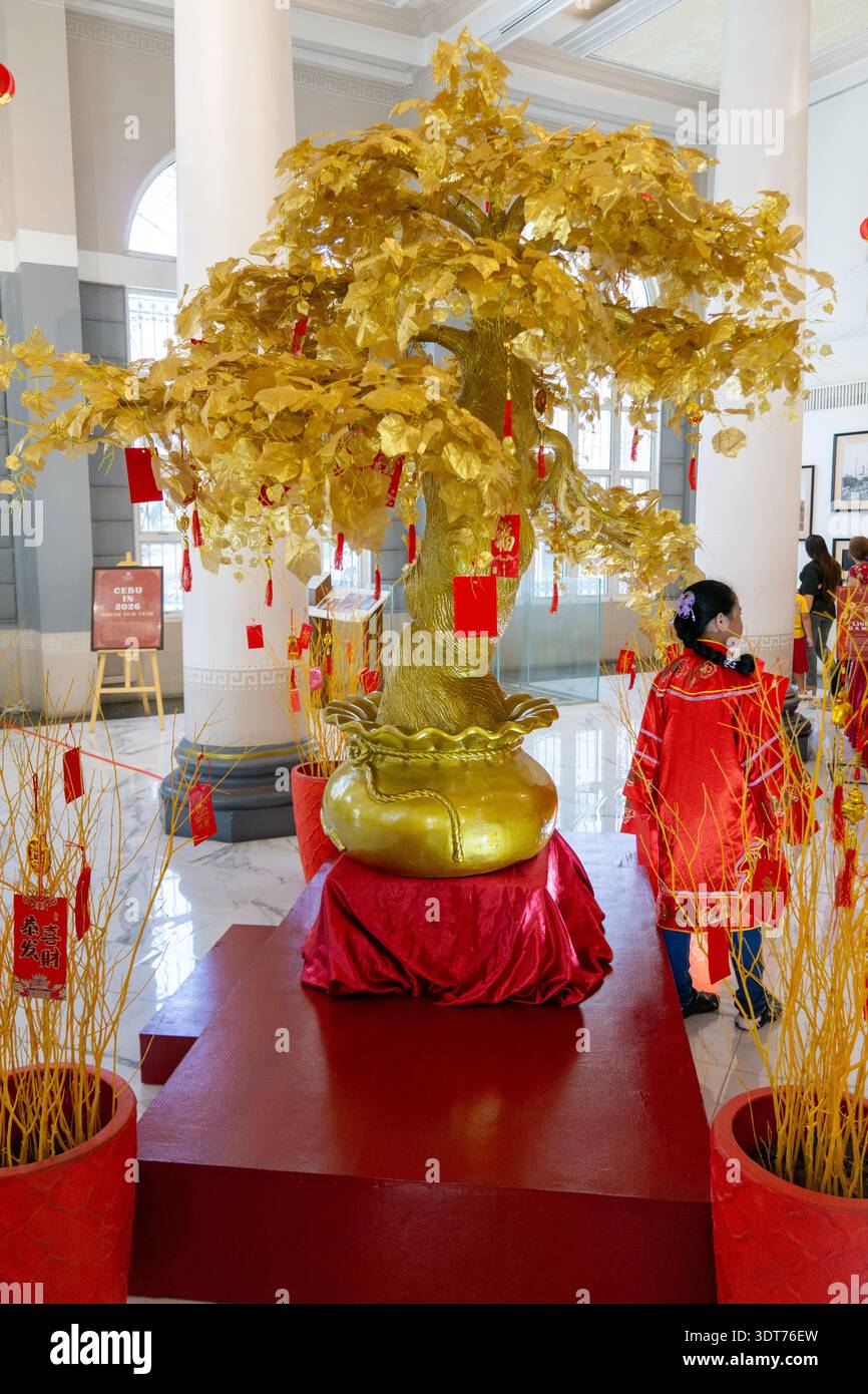 Arbre à souhait doré avec des enveloppes rouges et des décorations festives exposées à l'intérieur du musée du patrimoine chinois de Cebu pendant la célébration du nouvel an lunaire à Phil Banque D'Images