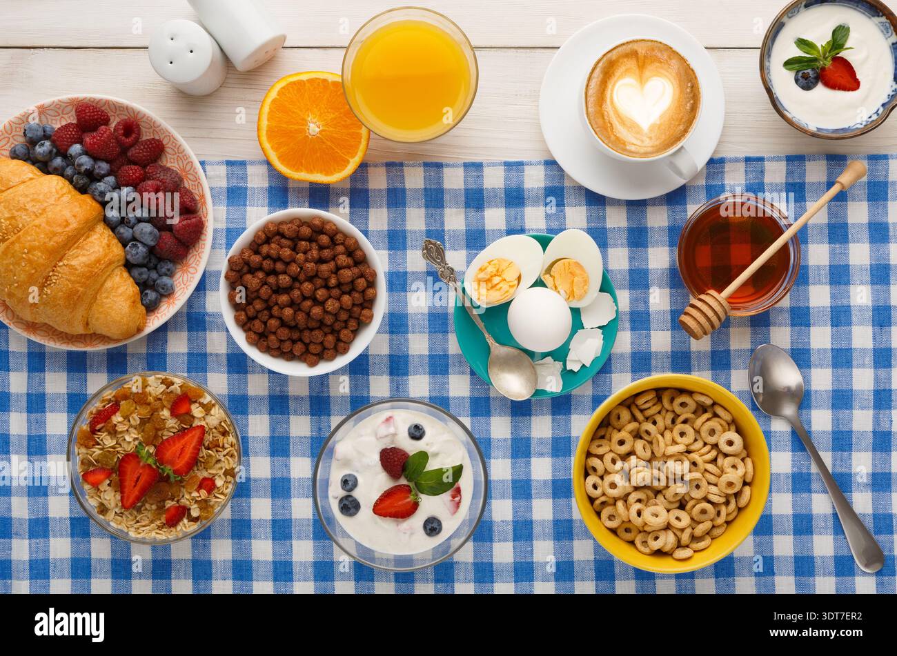 Petit déjeuner servi sur une nappe à carreaux avec divers aliments et boissons Banque D'Images