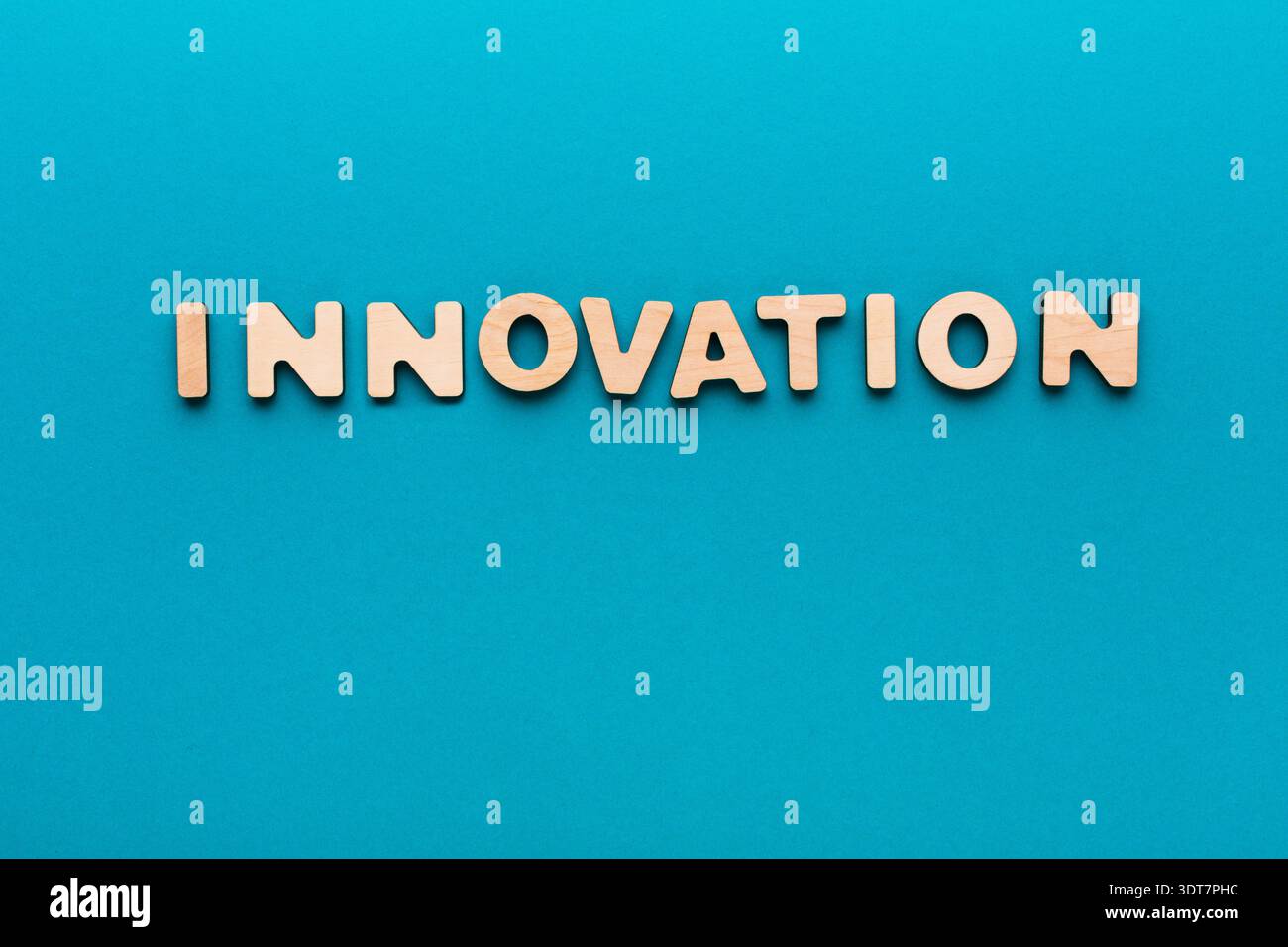 Les lettres en bois écrivent l'innovation sur un fond bleu dans ce concept de design créatif Banque D'Images