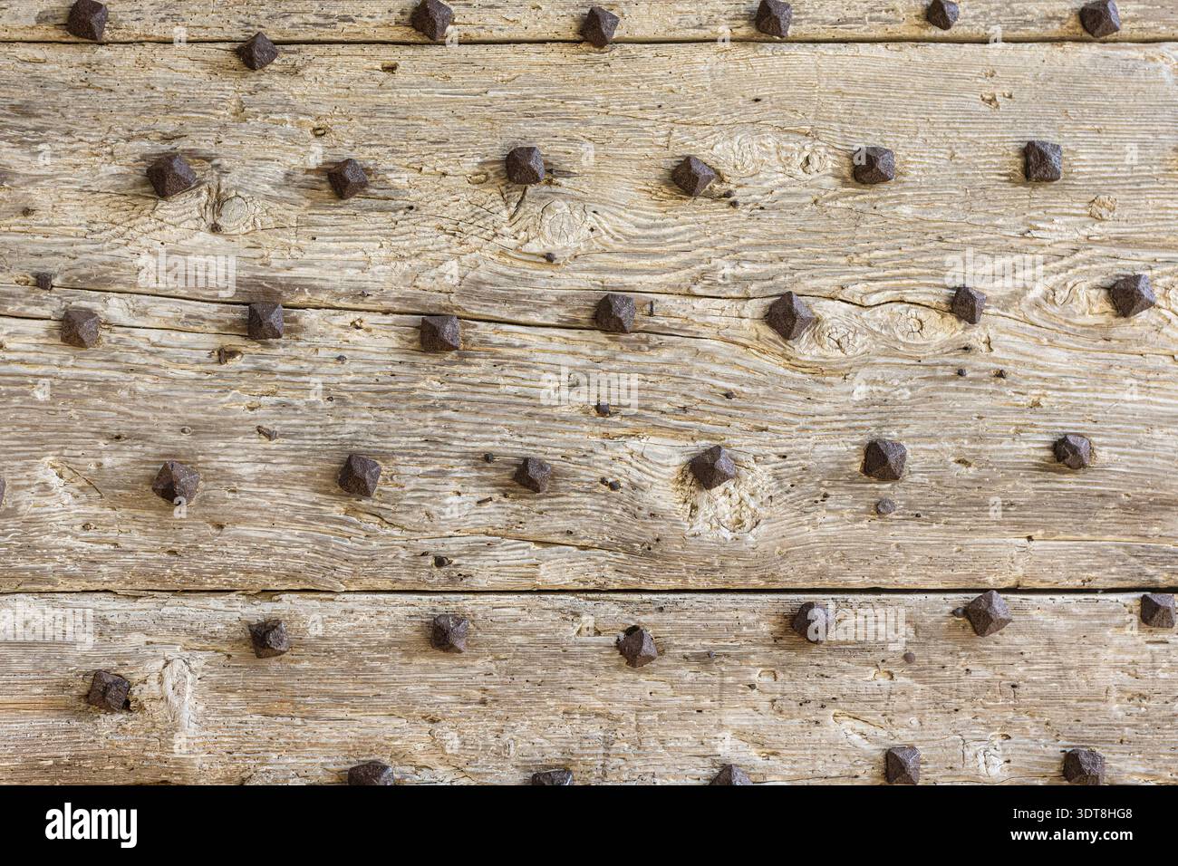 Surface de porte en bois vieilli avec planches texturées et détail clouté antique Banque D'Images