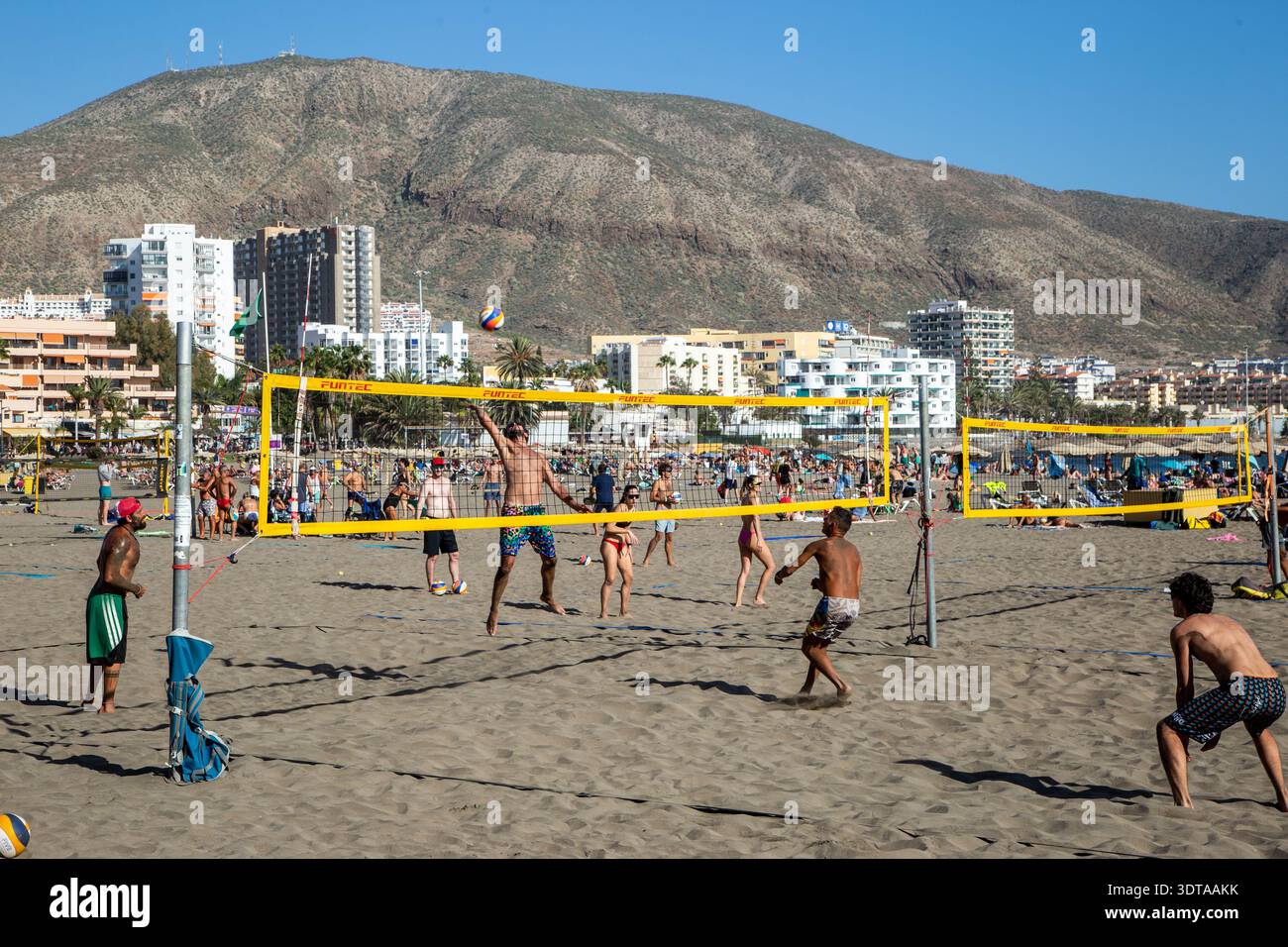 Les gens jouent au Beach volley sur le sable à la station balnéaire des Canaries Playa Los Cristianos Tenerife Espagne Banque D'Images