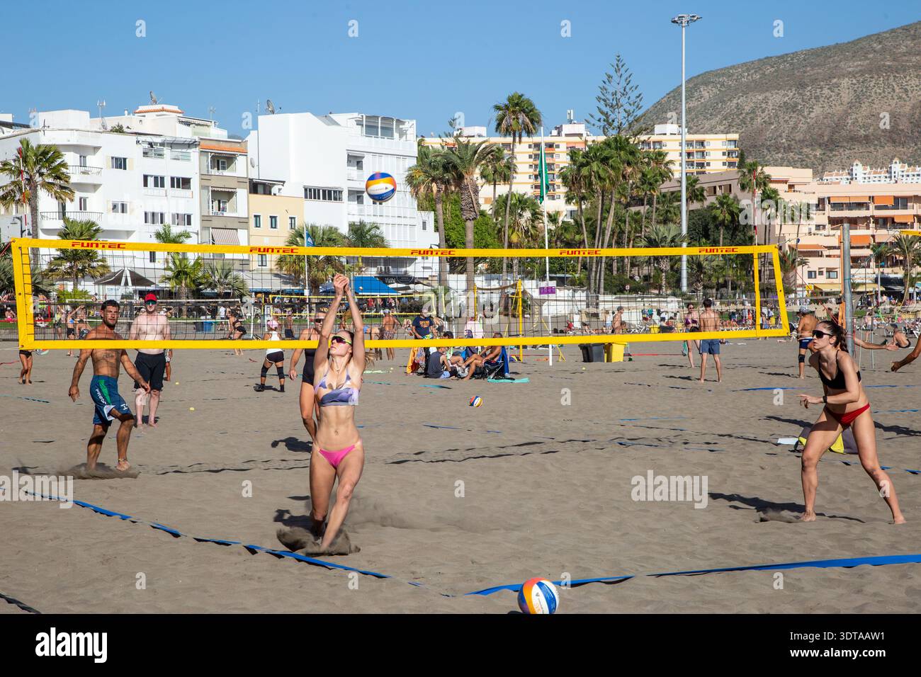 Les gens jouent au Beach volley sur le sable à la station balnéaire des Canaries Playa Los Cristianos Tenerife Espagne Banque D'Images