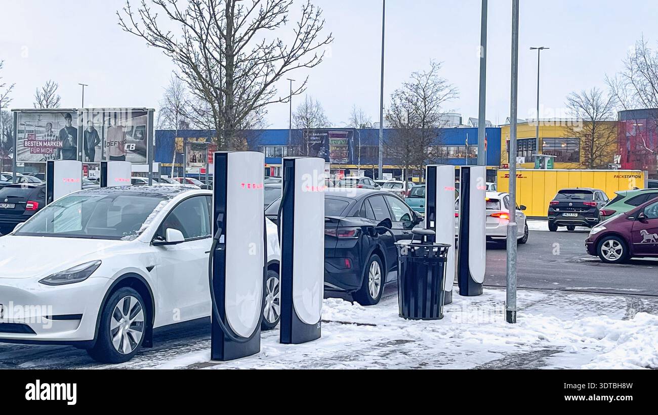15 février 2026, Lubeck, Allemagne : les véhicules Tesla se chargent à des compresseurs dans le parking enneigé du centre commercial Banque D'Images