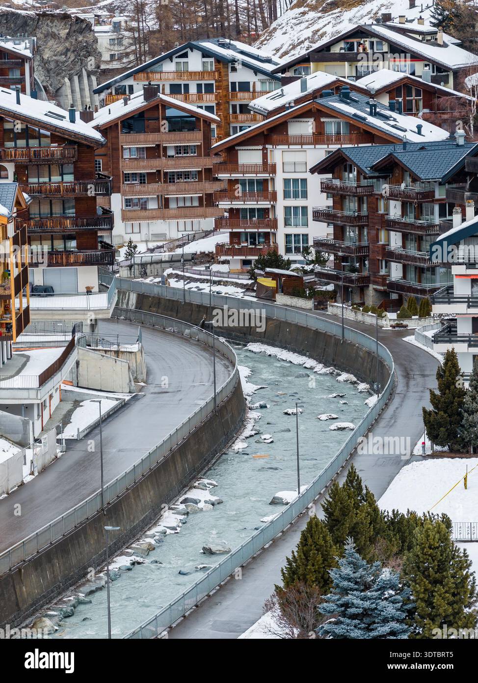 Rue courbe et canal fluvial à Zermatt avec hôtels de chalet Banque D'Images