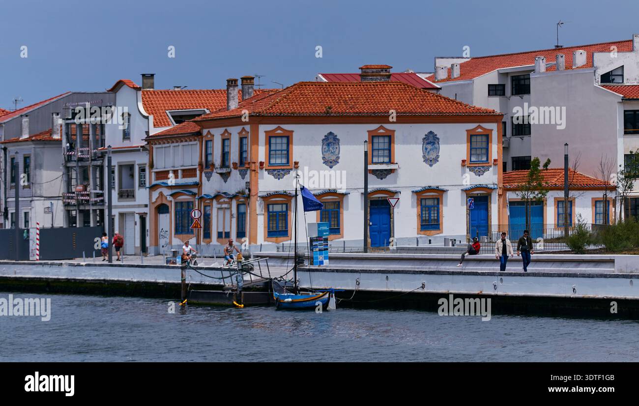 Aveiro, Portugal - 14 juin 2025 : bâtiments traditionnels en bord de mer avec des façades colorées et des bateaux de pêche le long de la rivière dans une ville côtière de Portug Banque D'Images