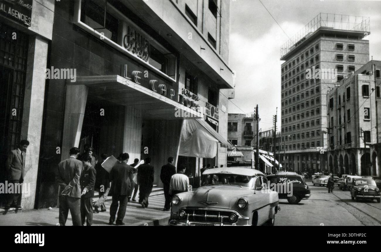Liban des années 1950 - voiture Chevrolet devant l'hôtel le Capitole dans le centre-ville cosmopolite de Beyrouth, avec le bâtiment Lazarieh en arrière-plan - pré-guerre civile Banque D'Images