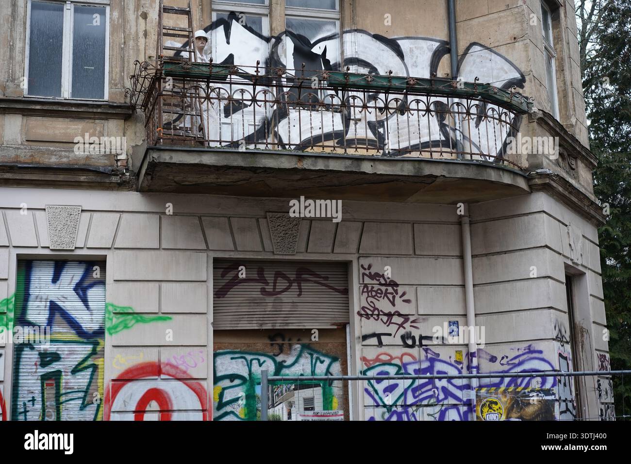 Berlin, Allemagne - 22 février 2026 : 'Geisterhaus Flora' abandonne le bâtiment Jugendstil avec graffiti et mannequin en vêtements de travail sur le balcon, Friedenau Banque D'Images