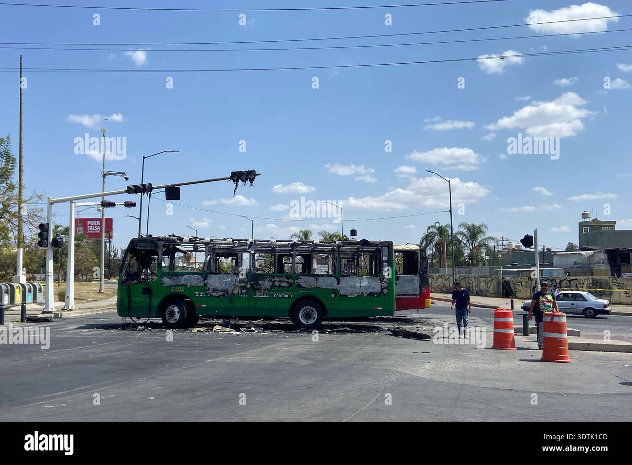 Pedestrians walk past charred buses that were set on fire, on a road in Guadalajara, Jalisco state, Mexico, Sunday, Feb. 22, 2026, after the death of the leader of the Jalisco New Generation Cartel, Nemesio Oseguera Cervantes, known as "El Mencho." (AP Photo/Refugio Ruiz) Banque D'Images
