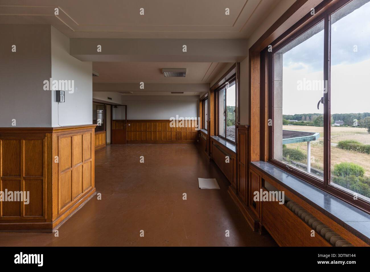 Chambre vide avec fenêtres et boiseries dans la station VRT/RTBF-TV, Wavre, Belgique Banque D'Images