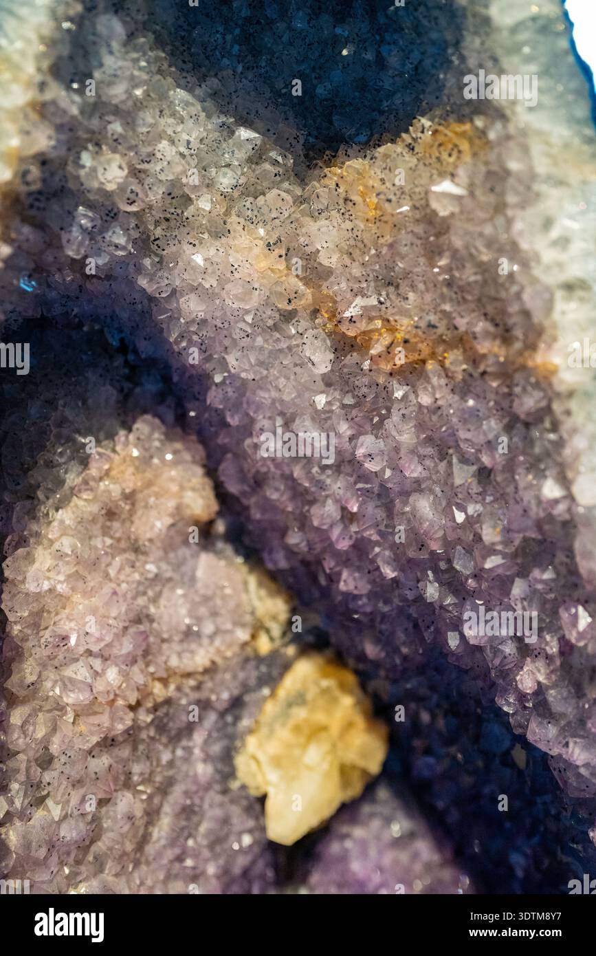 Détail d'un spécimen de cristal de quartz violet montrant des facettes géométriques naturelles et une coloration violette profonde avec une faible profondeur de champ artistique. Banque D'Images