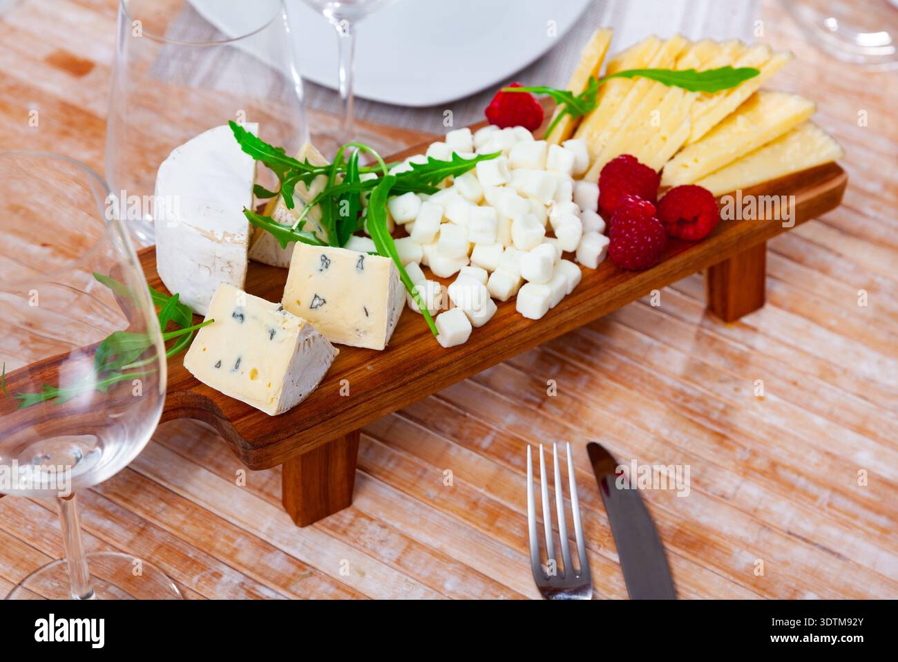Assortiment de fromages servis avec framboises et roquette Banque D'Images