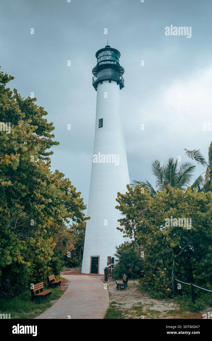 Cape Florida Lighthouse tour blanche debout haut contre un ciel couvert gris avec des palmiers verts dans Bill Baggs State Park, Key Largo, FL. Banque D'Images