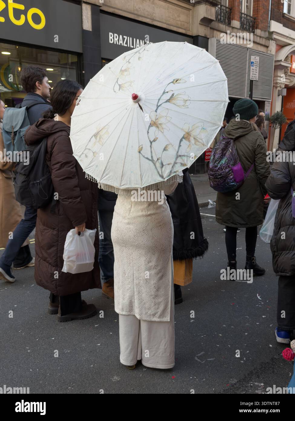 Londres, Royaume-Uni. 22 février 2026. Des célébrations animées se poursuivent dans Chinatown de Londres pour le nouvel an chinois, l'année du cheval de feu. Les points forts incluent de denses expositions de lanternes rouges traditionnelles au-dessus de Gerrard Street, une statue de lion en pierre cérémonielle ornée de décorations festives, et des foules rassemblées devant les restaurants locaux pour assister à des spectacles traditionnels de danse du lion. Crédit : Glosszoom/Alamy Live News Banque D'Images