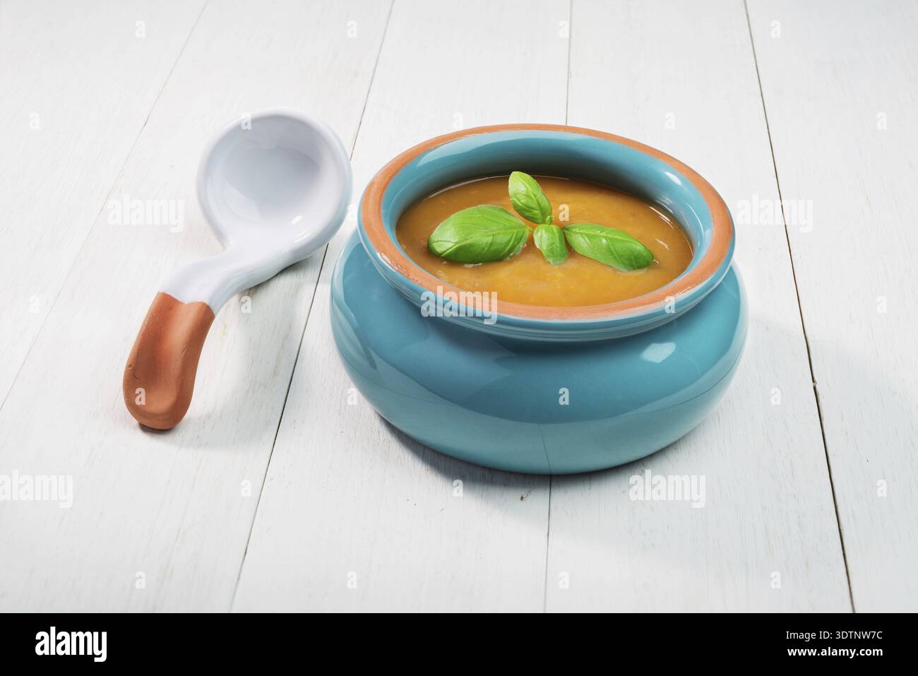 Soupe de citrouille fraîche dans un bol en céramique avec cuillère sur un vieux fond en bois Banque D'Images