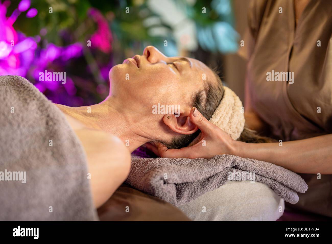 Femme détendue bénéficiant d'un traitement de soin du corps dans le salon de spa, recevant un massage de guérison de masseuse. Banque D'Images