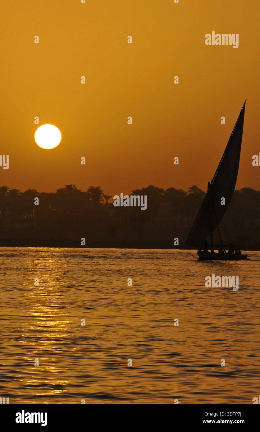 Coucher de soleil sur le Nil, Egypte avec un voilier felouque en silhouette Banque D'Images