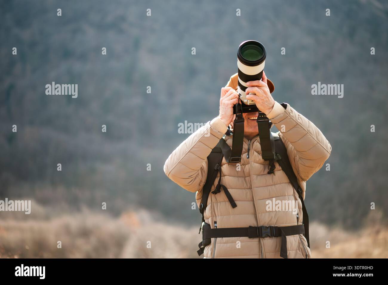 Un photographe expérimenté à dos explore les champs ouverts pour capturer une perspective unique de la nature. Banque D'Images