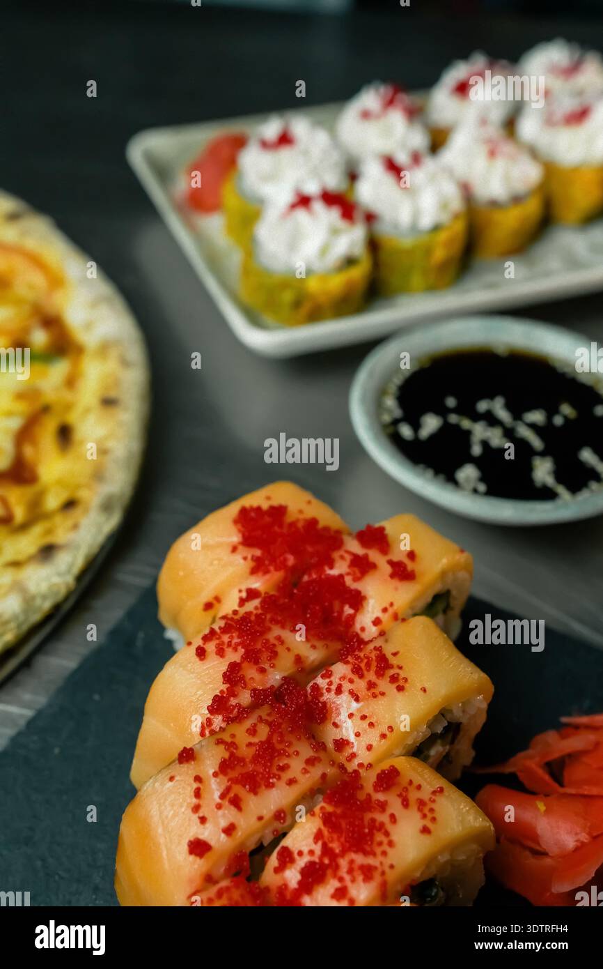 Délicieux assortiment de sushis et de cuisine japonaise avec petits pains colorés, ingrédients frais et desserts alléchants sur une table élégante Banque D'Images