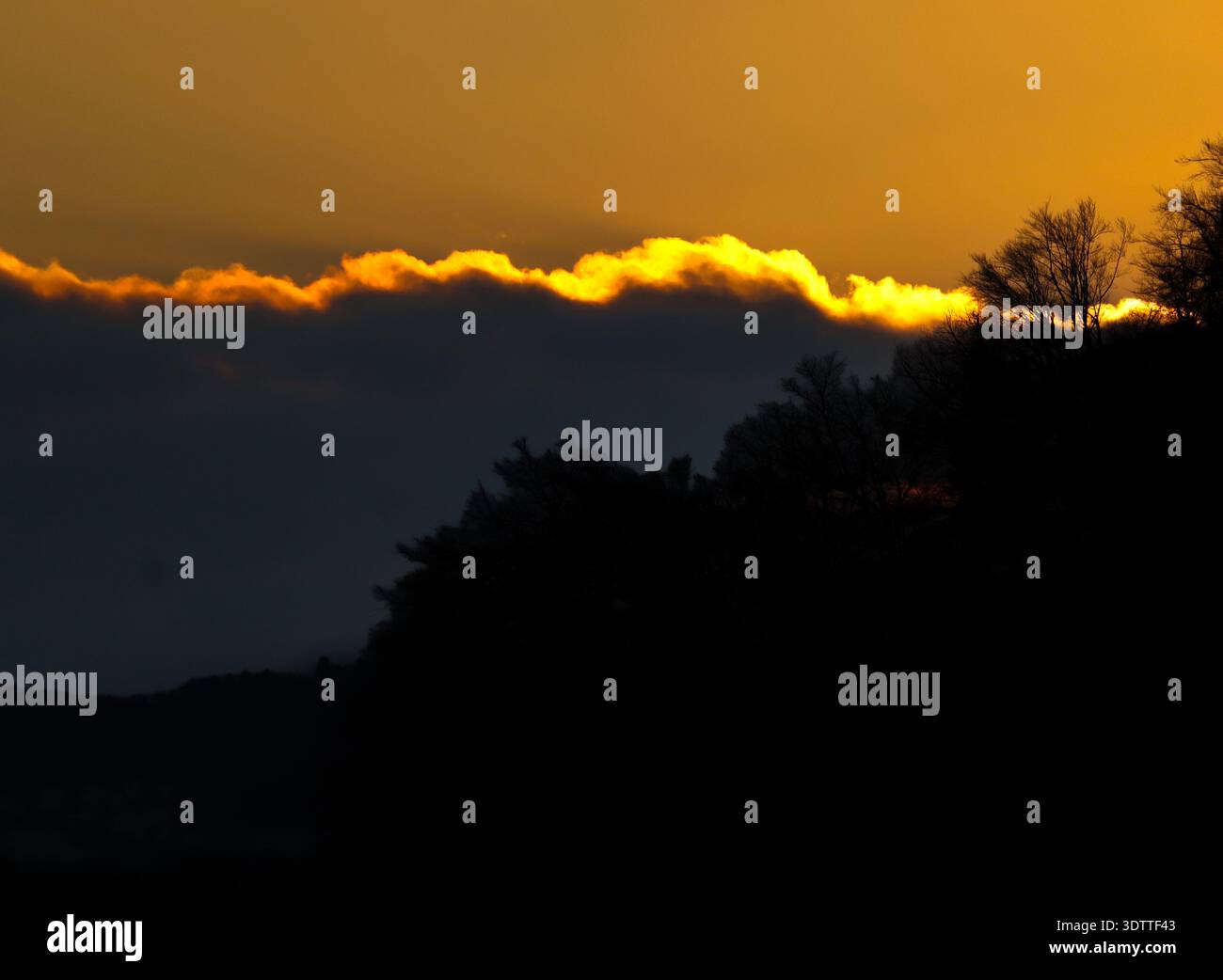 Chaque nuage a une doublure dorée. Un moment de drame intense alors que le soleil couchant enflamme le bord de l'horizon, projetant une lueur ardente sur le si silencieux Banque D'Images
