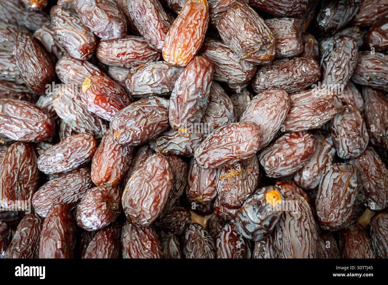 Gros plan des dates en vente sur un étal de marché alimentaire, montrant la riche couleur, la texture et l'abondance de ce fruit sec traditionnel dans un commerce de détail naturel Banque D'Images