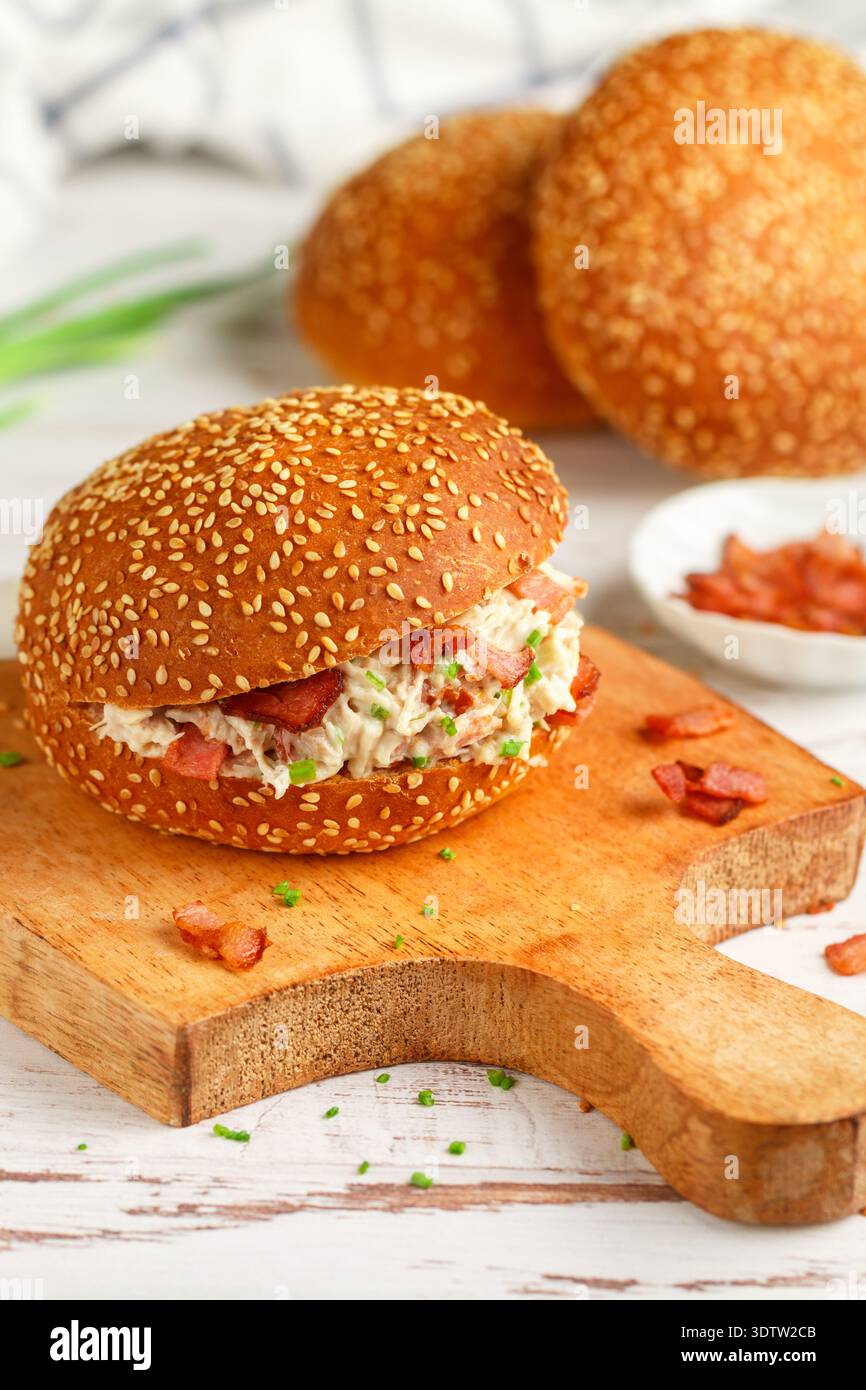 Délicieux sandwich pain au sésame avec salade de poulet, bacon frit, oignons verts, fromage avec sauce ranch. Déjeuner ou dîner pour les gourmets. Mise au point sélective Banque D'Images