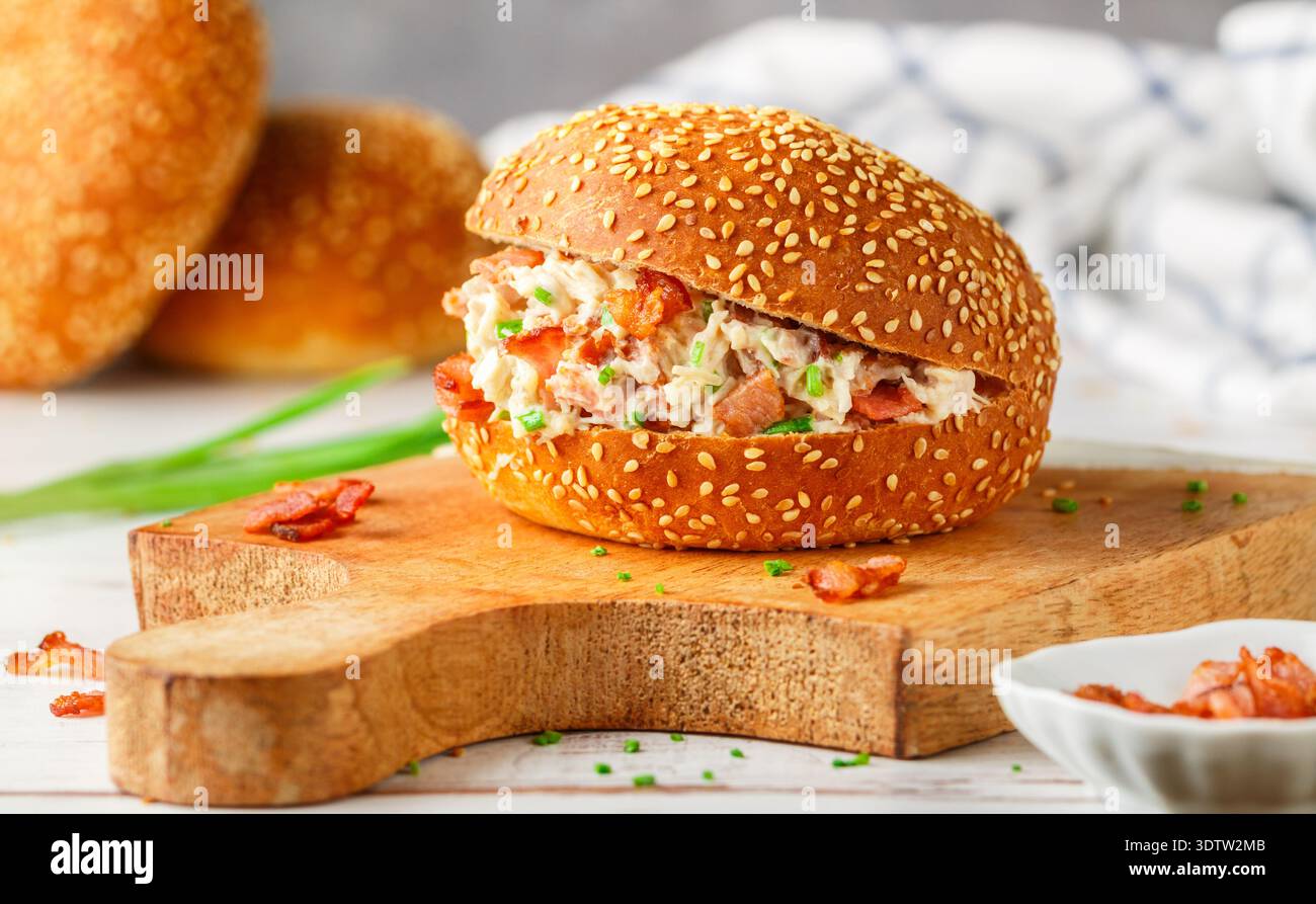 Délicieux sandwich pain au sésame avec salade de poulet, bacon frit, oignons verts, fromage avec sauce ranch. Déjeuner ou dîner pour les gourmets. Mise au point sélective Banque D'Images