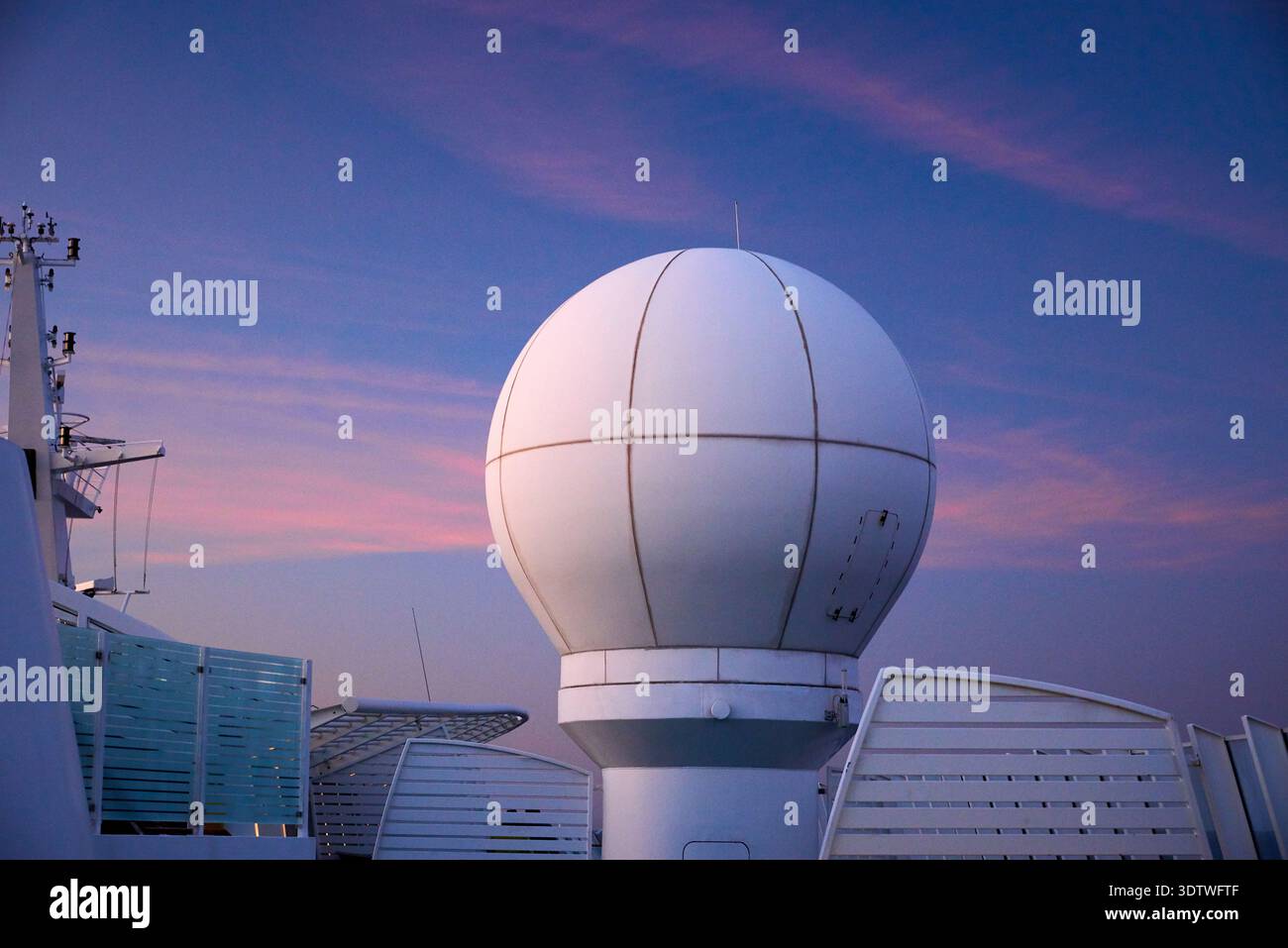 Un grand radôme sphérique blanc, abritant probablement une antenne radar, se trouve bien en vue sur un navire de croisière ou un grand navire. Il est positionné contre une bande Banque D'Images