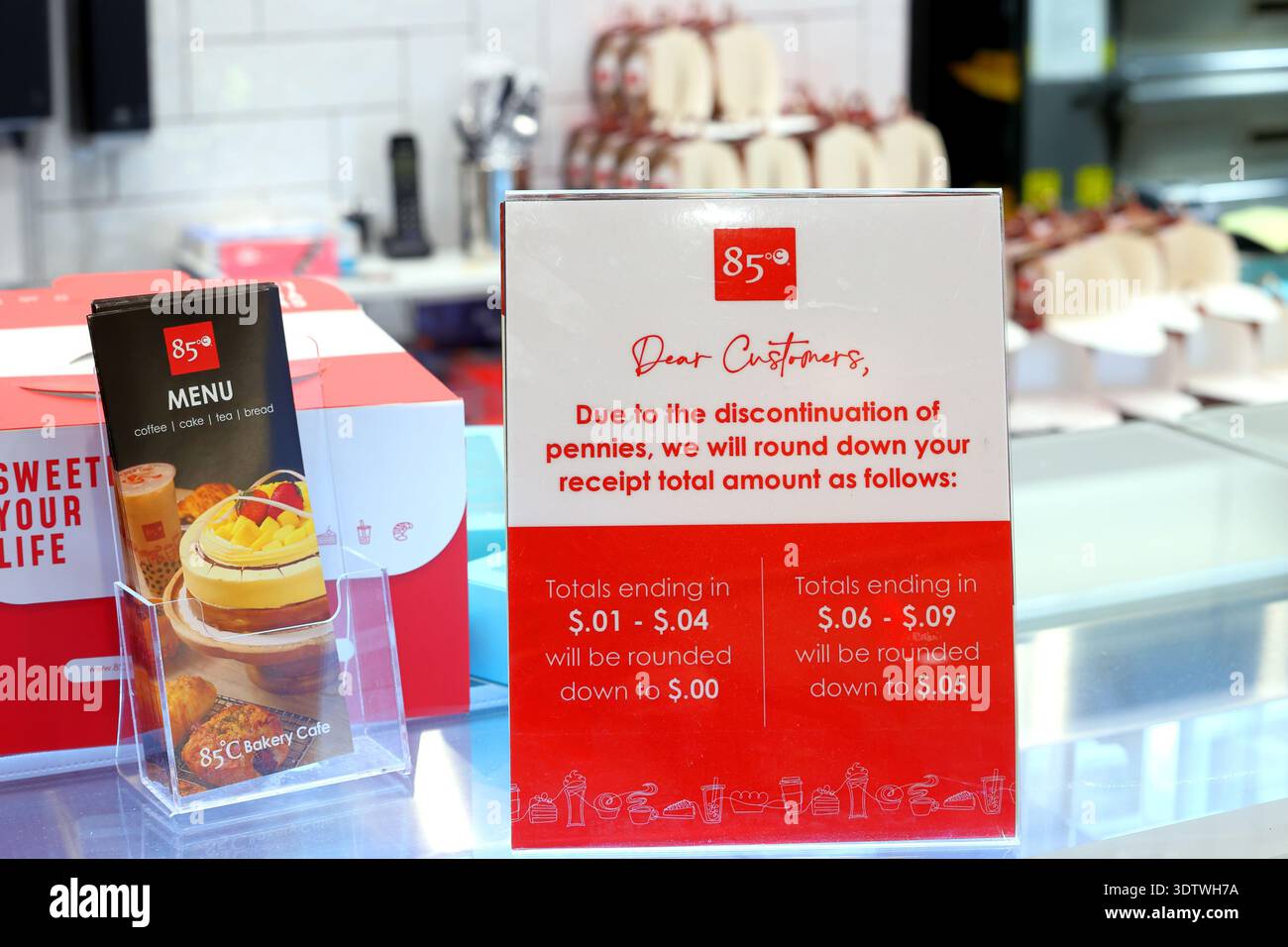 La signalisation dans une boulangerie avisant les clients des reçus totaux sera arrondie au 5 cents inférieur le plus proche en raison de l'arrêt de la vente de pièces d'un centime américain. 'Dû à Banque D'Images