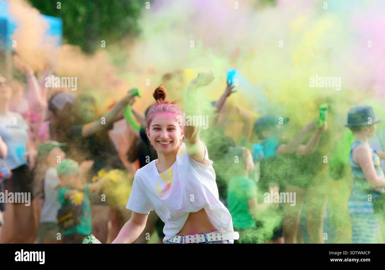 Fille dansant au milieu de la poudre colorée vibrante sur Holi Festival Banque D'Images
