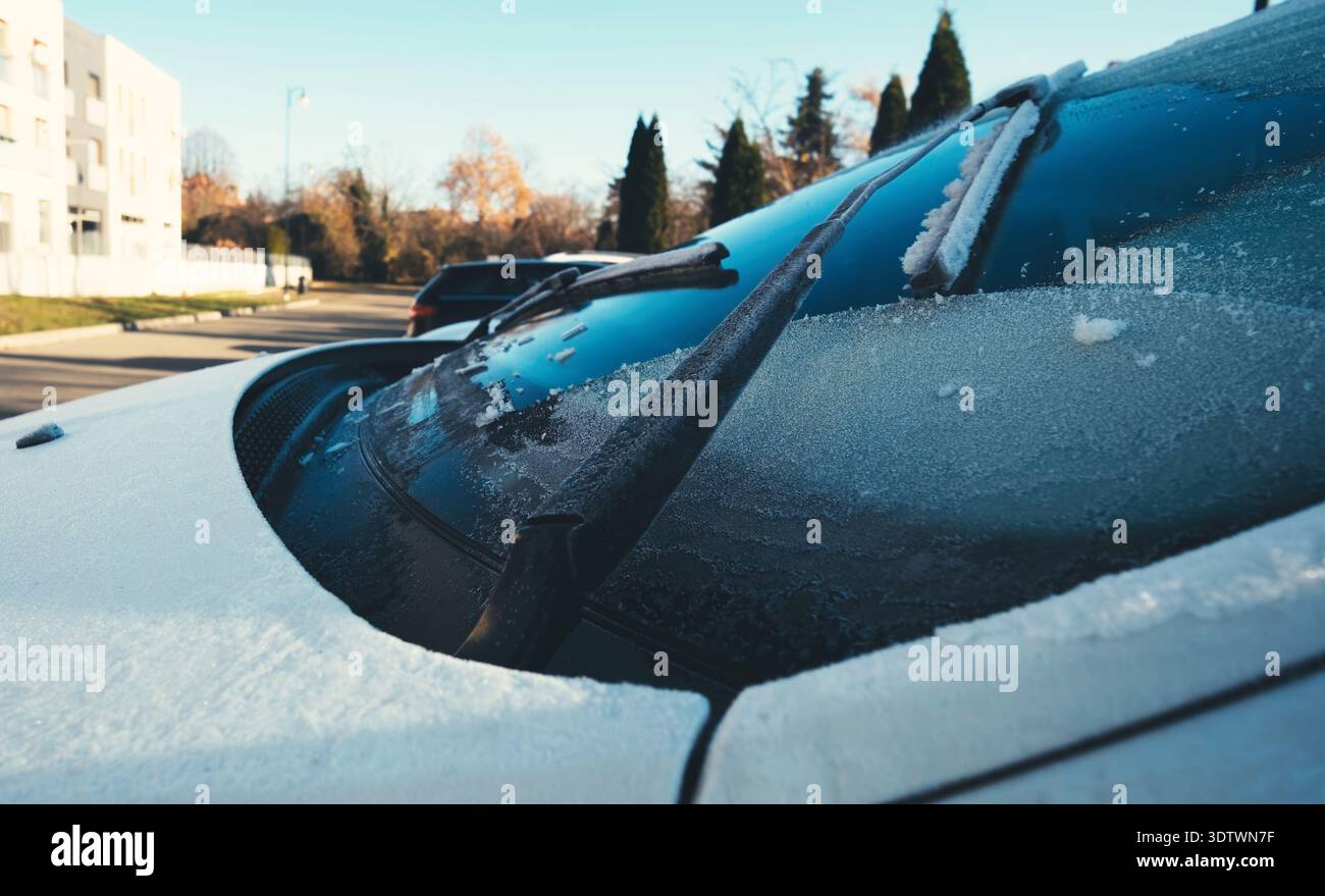 Essuie-glaces de pare-brise en fonctionnement de la voiture nettoyer la neige hors d'une voiture glacée le matin avec des gelées Banque D'Images