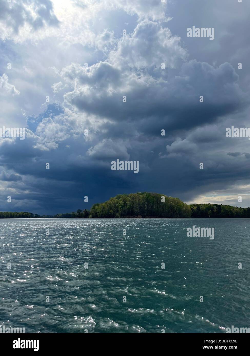 Approchant de la tempête avec le soleil se reflétant sur l'eau majestueuse sombre et les nuages. Banque D'Images