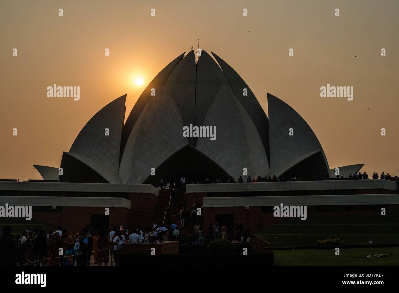 Les visiteurs marchent sur le terrain du Temple du Lotus au coucher du soleil à New Delhi. Banque D'Images