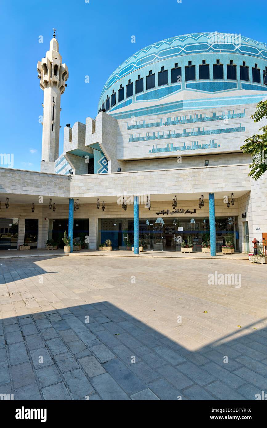 Les gens se promènent autour de la mosquée du Roi Abdullah à Amman en Jordanie. Le soleil brille sur la mosquée et ses environs. Banque D'Images