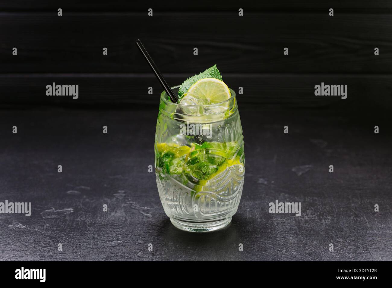 Cocktail de mojito frais avec citron vert, menthe et glace dans le verre sur fond sombre Banque D'Images