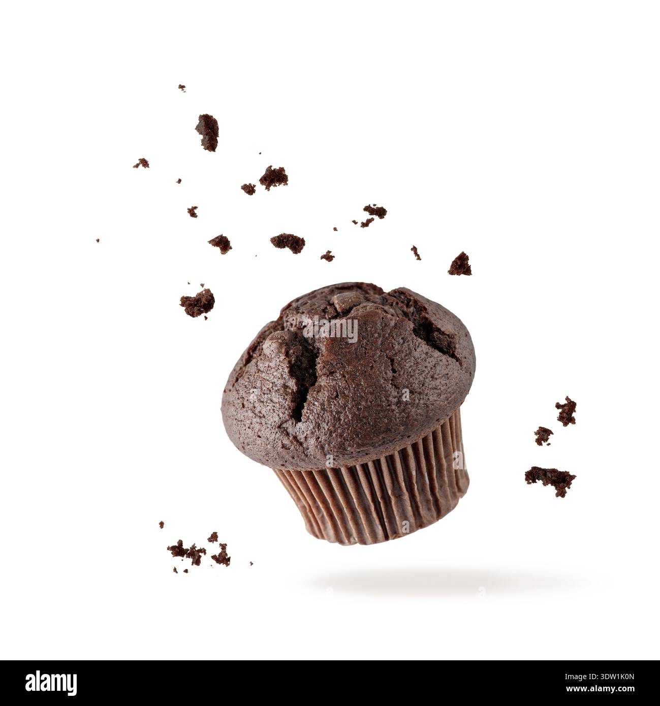 Muffin simple au chocolat frais cuit avec des miettes volant sur fond blanc. Petit gâteau noir doux tombant. Carte de pâtisserie avec espace de copie Banque D'Images