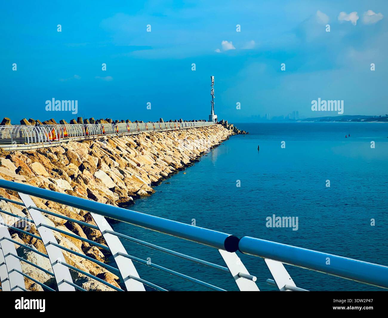 Une vue depuis la jetée d'Ashkelon, le phare et la marina par un matin d'été clair et ensoleillé. De nombreux voiliers avec leurs voiles abaissées sont amarrés Banque D'Images