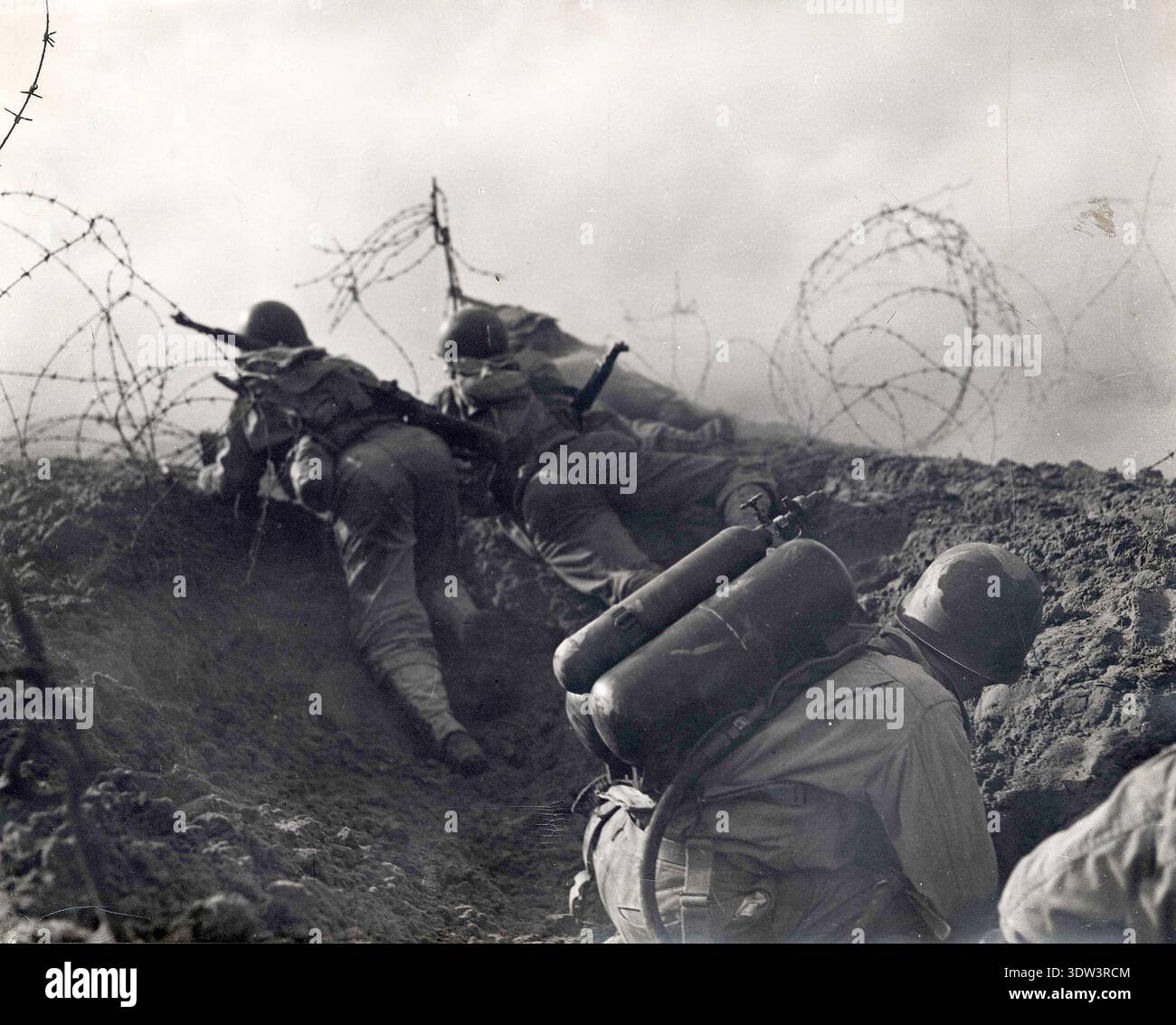 Deux soldats quittent un trou de foxhole pendant les exercices d'entraînement du jour J avant le jour J. n le 6 juin 1944, une énorme force d'invasion Alllied impliquant 7000 navires et 140 000 hommes débarque avec succès sur les côtes françaises et établit cinq têtes de plage. Une campagne de tromperie réussie signifiait qu'une grande partie de la résistance allemande était à Calais et que les pertes étaient relativement peu nombreuses compte tenu de l'ampleur et des dangers de l'opération. Banque D'Images
