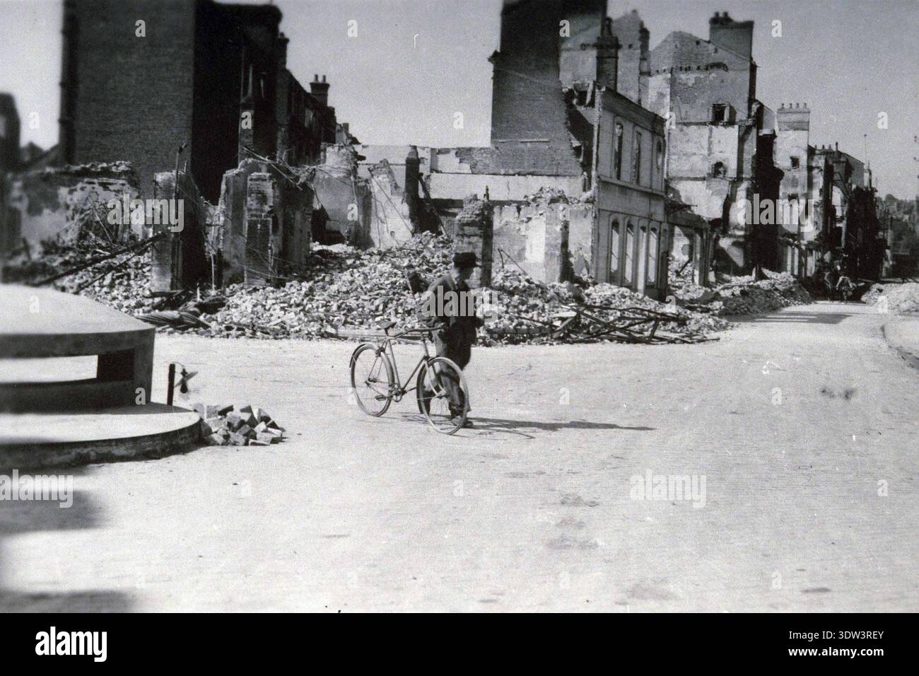 Civils dans la ville dévastée de Lisieux après le raid aérien allié du 6 juin 1944. Le 6 juin 1944, une énorme force d'invasion Alllied impliquant 7000 navires et 140 000 hommes débarque avec succès sur les côtes françaises et établit cinq têtes de plage. Une campagne de tromperie réussie signifiait qu'une grande partie de la résistance allemande était à Calais et que les pertes étaient relativement peu nombreuses compte tenu de l'ampleur et des dangers de l'opération. De nombreuses villes françaises historiques ont été détruites avant et pendant les débarquements. Banque D'Images