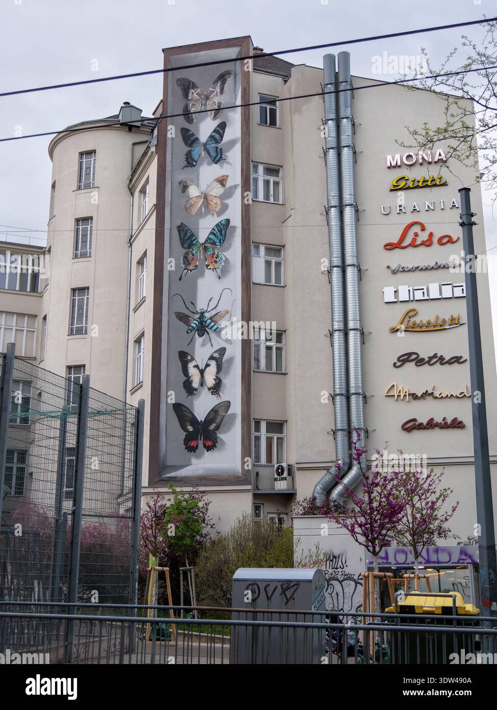 Murale verticale de papillon sur la façade de l'immeuble d'appartements de Vienne, papillons encadrés colorés, signes de marque adjacents, scène urbaine de Street art. Banque D'Images