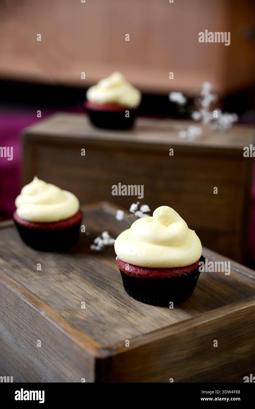 Biscuits esthétiques et cupcakes à la crème sur un fond en bois rustique. Banque D'Images