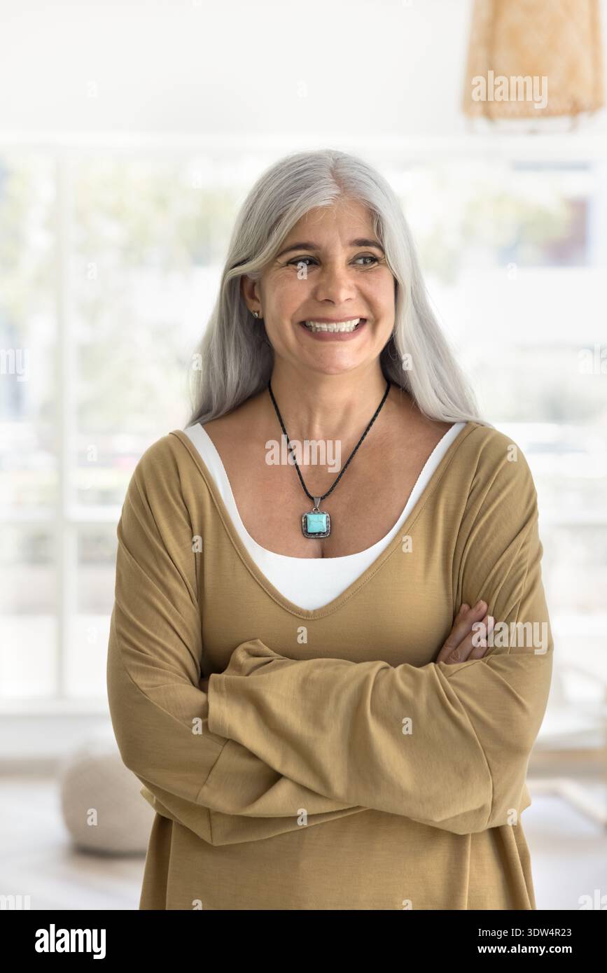 Femme pensive d'âge moyen posant seule dans le salon Banque D'Images