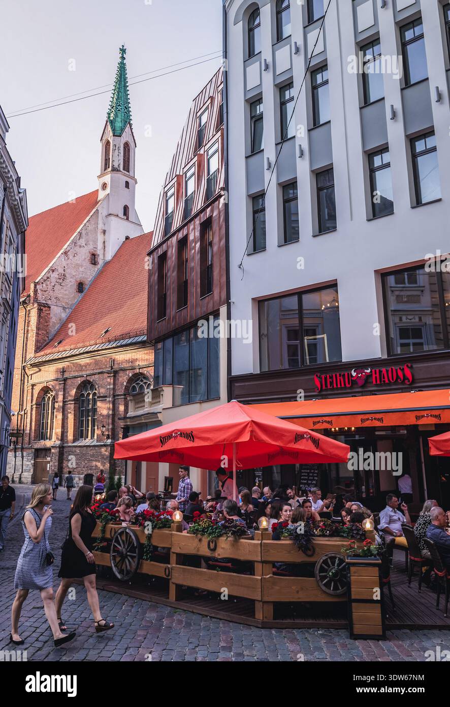 Riga, Lettonie - 25 juin 2016 : Restaurant Steiku Haoss sur la vieille ville de Riga, vue avec clocher de l'église Saint-Jean Banque D'Images