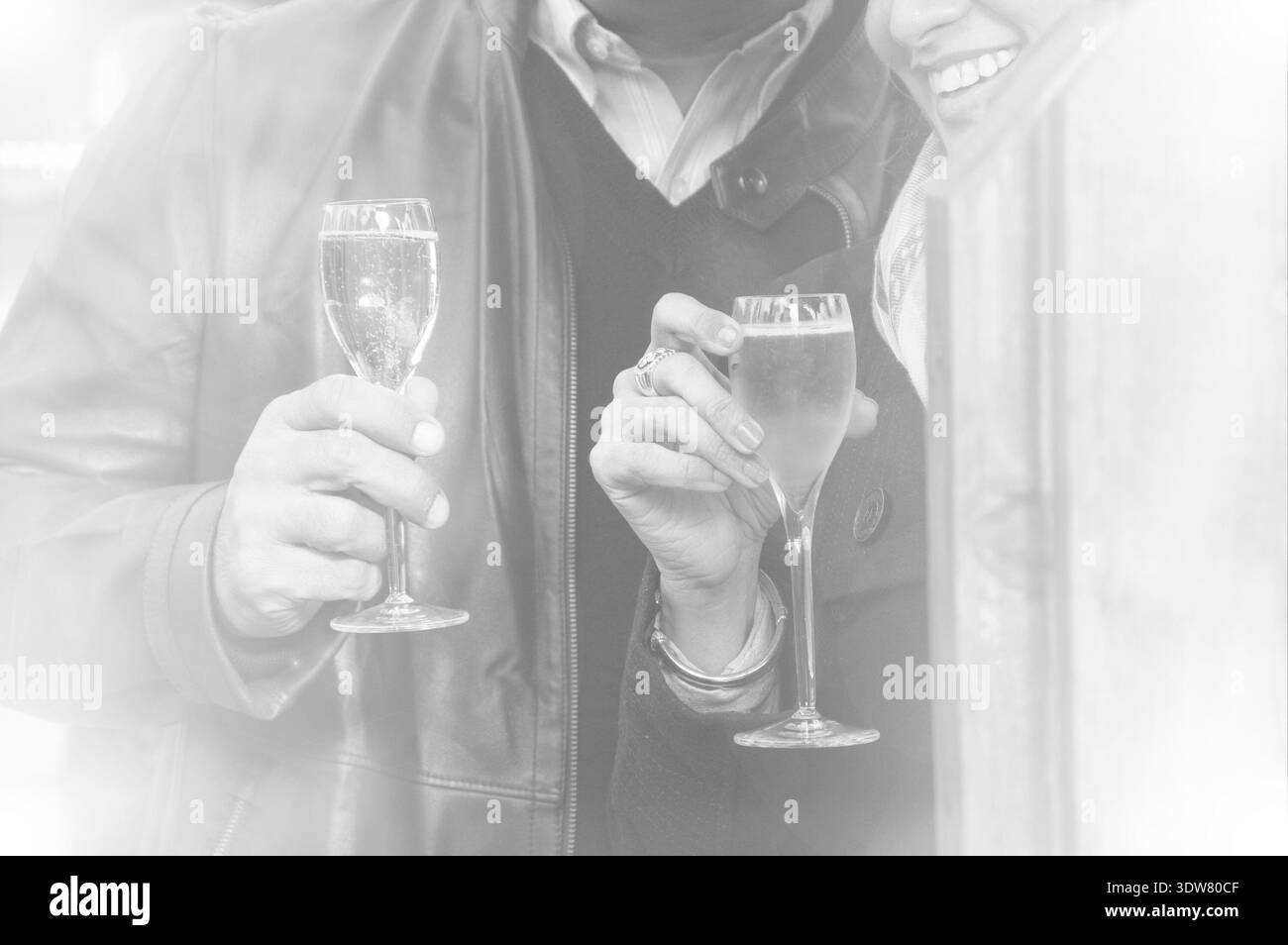 Heureux couple buvant du champagne au marché de Noël. Photo tonifiée. Noir et blanc. Banque D'Images