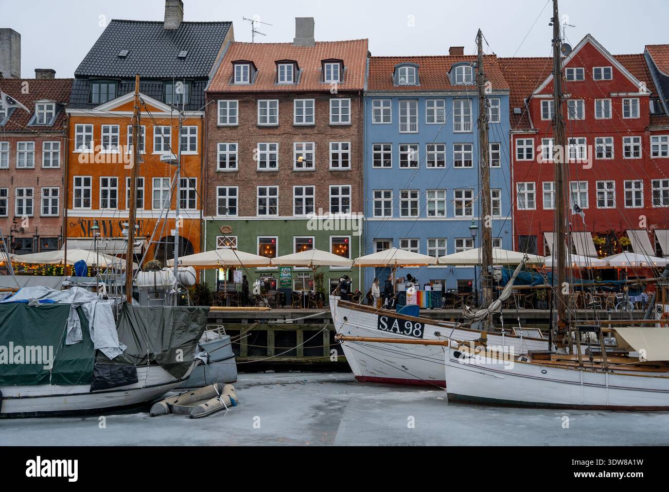 Port historique de Nyhavn avec des maisons de ville colorées et des bateaux traditionnels dans la glace d'hiver Banque D'Images