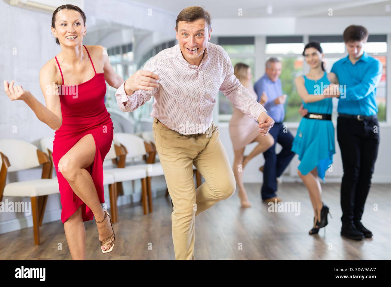 Couple dynamique s'engageant dans la danse latino en studio de danse. Danse de salle de bal par paires en studio Banque D'Images