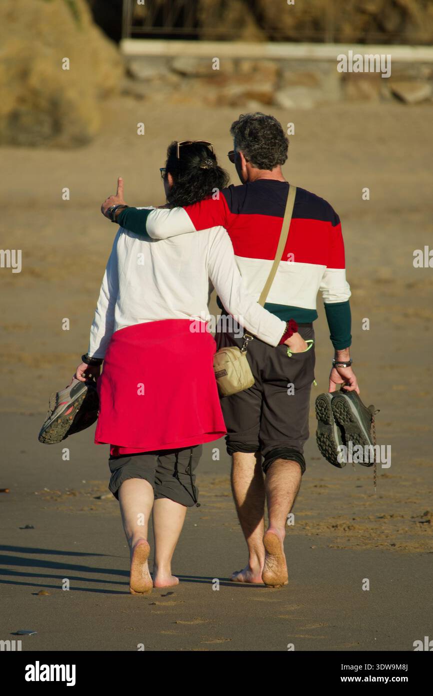 Couple d'âge moyen se promenant sur la plage de Bakio, pays Basque, Espagne Banque D'Images